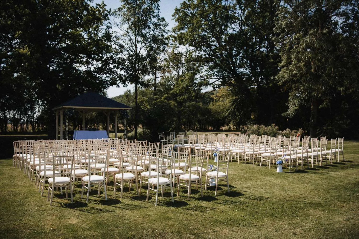 Colville Hall outdoor wedding setting. Chairs lined in front of the wooden Pagoda. 