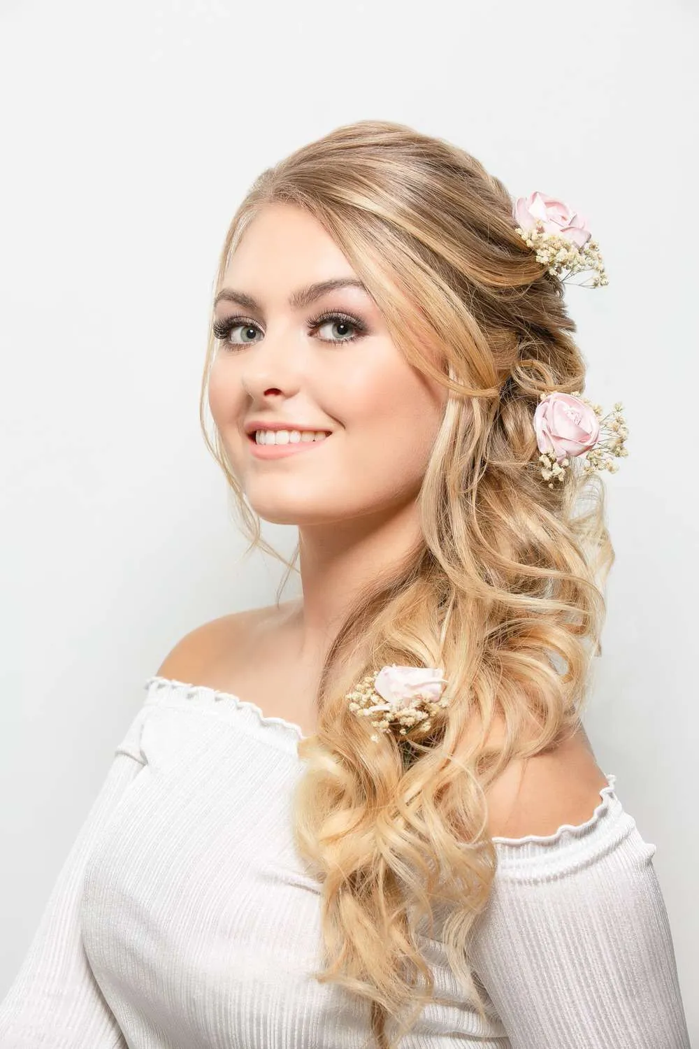 Standing model against white wall. Blonde hair with makeup on