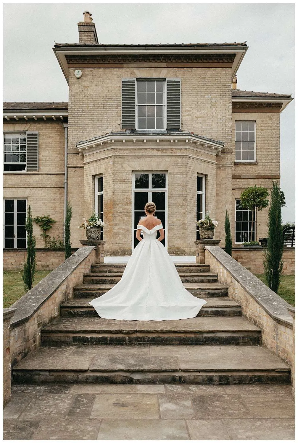 An image of the bride in her dress on the stairs