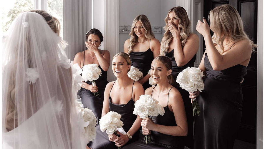 The bride reveals her dress to the bridesmaids