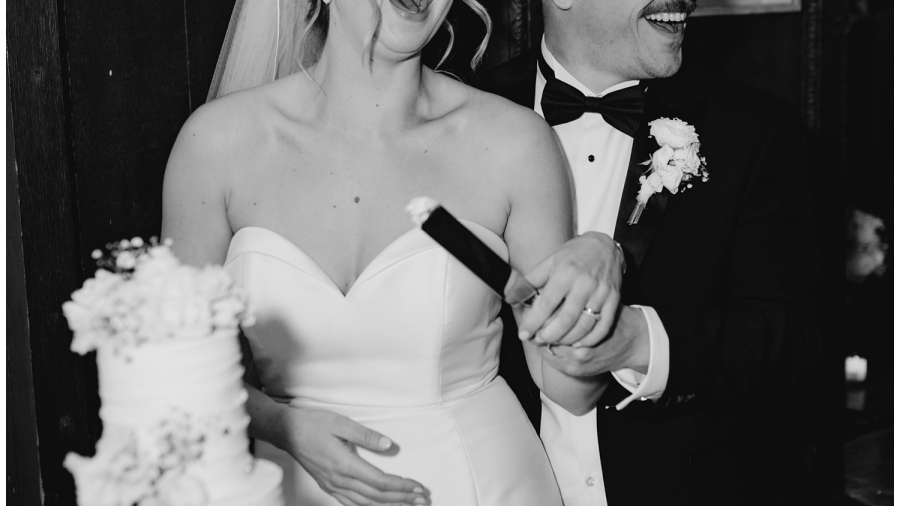 Essex estate wedding photography - The bride and groom cut the cake and laugh