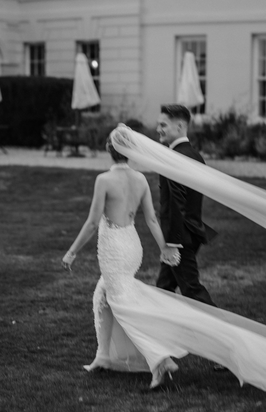 Editorial luxury for couples who hate posing. Genuine bride and groom moment walking at Gosfield Hall