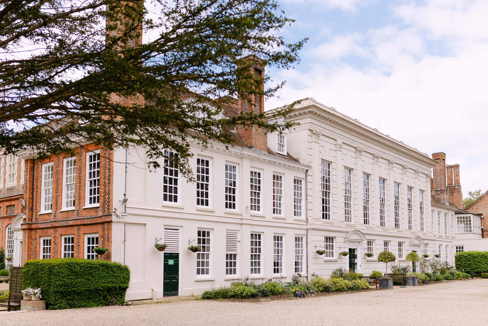 Gosfield Hall in Essex surrounded by its gardens during Molly and Taylor's June wedding