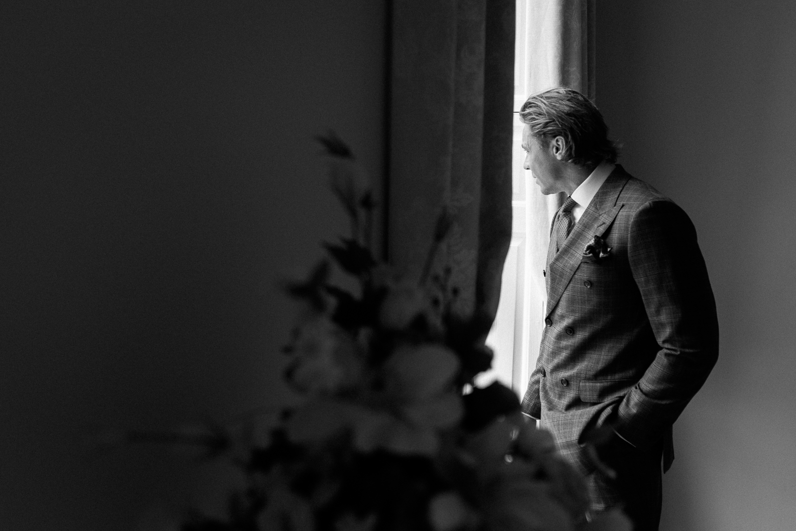 Black and white portrait of Taylor getting ready beside a window