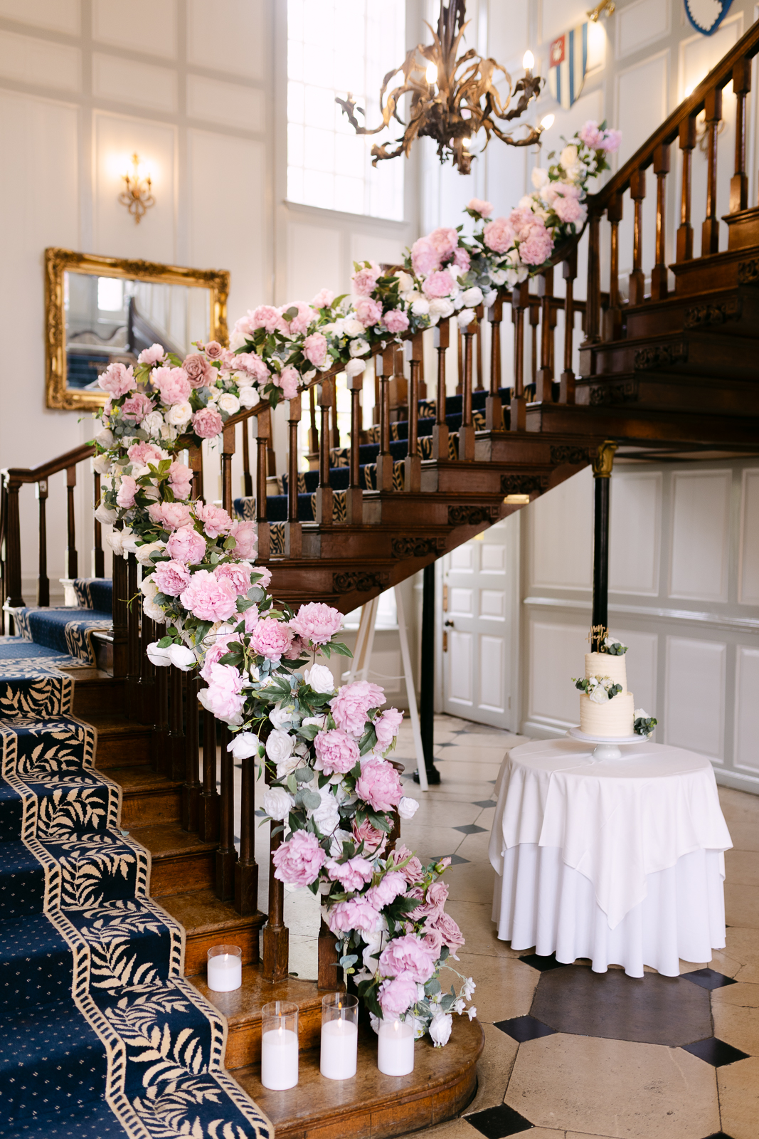 Gosfield Hall staircase decorated with pink and white wedding flowers