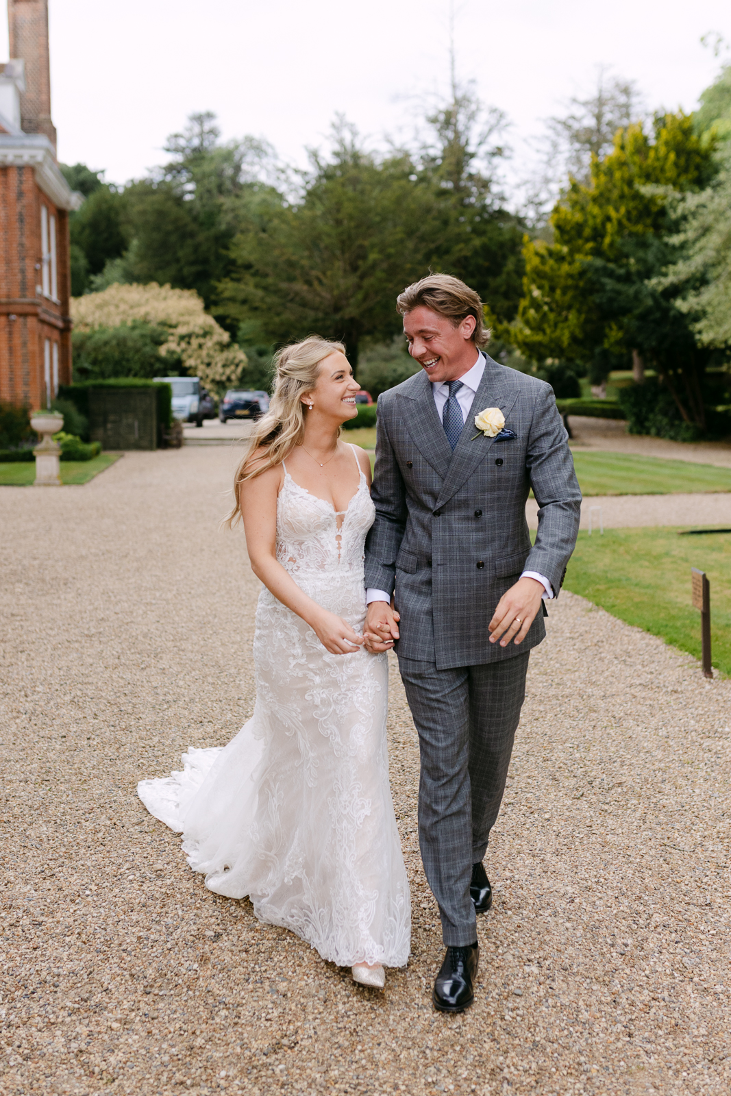 Molly and Taylor walking together after their wedding ceremony at Gosfield Hall in Essex